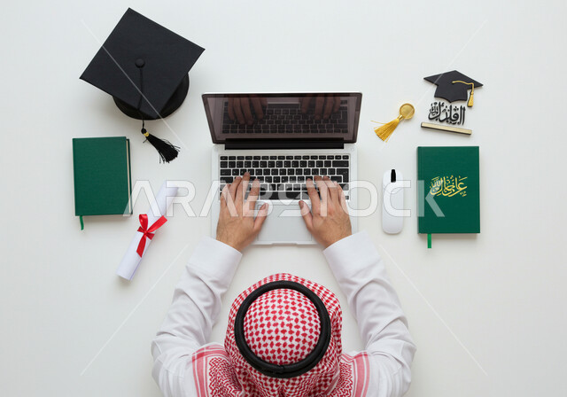 التعليم في المملكة العربية السعودية, مفهوم الاجتهاد والتفوق، بورتريه علوي عامودي لرجل عربي خليجي سعودي يرتدي الثوب التقليدي والشماغ يقوم بكتابة بحث على الحاسوب المحمول وبجانبه قبعة التخرج والشهادة، خلفية بيضاء