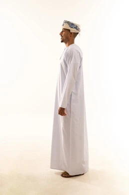 Personal appearance care, the concept of masculinity and dignity, expressions of self-confidence, a side portrait of an Omani Gulf Arab man wearing a dishdasha and turban standing upright, full body, white background.