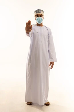 طلب التوقف وعدم الاقتراب،  تعابير الحزم والجدية، مفهوم الرفض والامتناع والانزعاج, بورتريه لرجل عربي خليجي عماني يرتدي الدشداشة و العمامة و الكمامة يمد يده نحو الأمام مع رفع الكف بإيماءات النهي عن فعل امر ما, الجسم بالطول الكامل، خلفية بيضاء