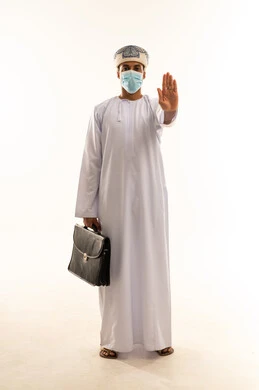 تعابير الحزم والجدية، مفهوم الرفض والامتناع والانزعاج, بورتريه لرجل عربي خليجي عماني يرتدي الدشداشة و العمامة و الكمامة يحمل حقيبه العمل يمد يده نحو الأمام مع رفع الكف بإيماءات النهي عن فعل امر ما, طلب التوقف وعدم الاقتراب, الجسم بالطول الكامل، خلفية بيضاء