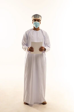 Review of the meeting results, a portrait of an Arab Gulf Omani man wearing a dishdasha, turban, and mask, holding papers in his hands, looking at the camera with gestures of seriousness and confidence, taking notes and preparing the daily report, feasibility study of the work, full-body shot, white background.