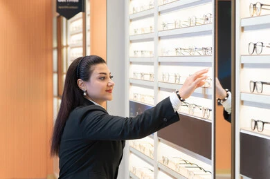 تعديل وتحسين الرؤية، الأناقة والاهتمام بالمظهر الخارجي، سيدة عربية خليجية اماراتيه ترتدي الزي الرسمي تقوم باختيار نظارة طبية ملائمة لملامح الوجه، امرأة سعوديه تقوم بشراء النظارات الخاصة بضعف وقصرالنظر، متعة التسوق في الأسواق والمحلات الإماراتية