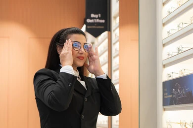 Improving and correcting vision, the positive impact of shopping on women, admiring new eyeglasses, the concept of poor vision, a close-up of a Saudi Arabian Gulf woman in formal dress choosing eyeglasses that fit her facial features, an Emirati woman examining eyeglasses