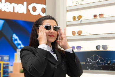 التأثير الإيجابي للتسوق على المرأة، اكسسوارات نسائية عصرية، الاهتمام بالمظهر الخارجي، تجربة النظارات الشمسيه قبل الشراء، امرأة اماراتية تقوم باختيار نظارة شمسيه مناسبة، سيدة عربية خليجية سعودية ترتدي الزي الرسمي تقوم بقياس نظاره