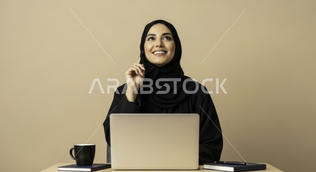  مهنة ووظيفة نسائية مكتبية سعودية، ادارة وانجاز المهام باستخدام جهاز تقني حديث ومتطور, بورتريه مقرب لإمرأة عربية خليجية سعودية مبتسمة ترتدي الحجاب والعباءة تعمل على الحاسوب المحمول، ايماءات وتعابير السرور والسعادة، خلفية بيج
