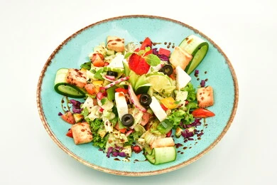 A plate of fattoush decorated with fried bread and pomegranate seeds, a bowl full of fresh vegetable pieces, traditional popular dishes in Saudi Arabia, oriental food restaurants, artistic methods of food presentation, white background