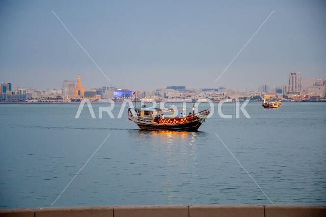 A wooden boat in the middle of the Red Sea in Doha during the day, famous tourist places and landmarks in Qatar, attracting and attracting tourists from all over the world