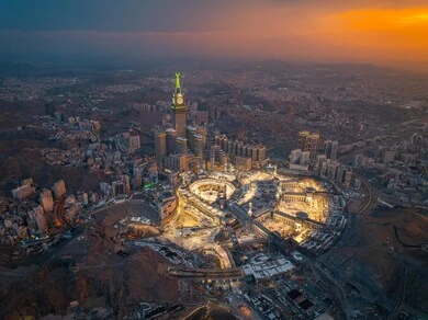 A sacred religious site and landmark in the Kingdom of Saudi Arabia, an aerial view of the architectural art of towers and skyscrapers in Mecca, a destination for Muslims from different countries, the progress and urban growth of hotels and buildings overlooking the Grand Mosque