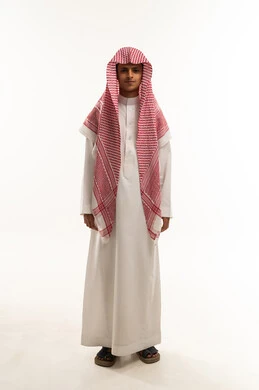 The concept of attention to external appearance, looking at the camera with gestures of happiness and joy, a portrait of an Arab Gulf Saudi boy wearing a thobe and a shemagh, gestures of attractiveness and masculinity, full-body, white background.