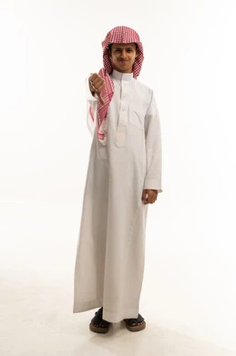 مفهوم التقييم السلبي والانزعاج، الفشل في تحقيق أمر ما، بورتريه لولدعربي خليجي سعودي  يرتديالثوب الابيض و الشماغ ينظر الى الكاميرا يشير بإصبع الابهام الى الاسفل بإيماءات الرفض وعدم القبول والرضا، صورة الجسم بالطول الكامل، خلفية بيضاء