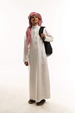 Looking at something above, preparing for the new school year, back to school, a portrait of an Arab Gulf Saudi student wearing a white thobe and a shemagh, carrying a backpack, looking with gestures of happiness and joy, expressions of enthusiasm and energy, full-body, white background.
