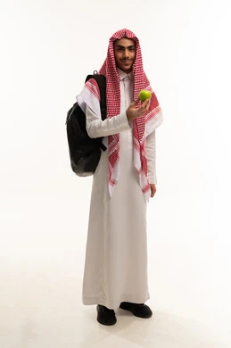 Natural and fresh fruit, the importance of the nutrients found in apples, healthy and balanced food, a portrait of a Saudi Gulf Arab student wearing traditional attire and a ghutrah, holding an apple with a backpack, following a diet, a delicious snack, full-body shot, white background.