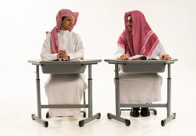 بداية موسم التعليم، إيماءات الاجتهاد والتفوق, بورترية لطالبان عربيان خليجيان سعوديان يرتديان الثوب الابيض و الشماغ يجلسان على الطاولة يقومان بمراجعة الدروس للمذاكرة والاختبارات المدرسية ينظران الى بعض، خلفية بيضاء