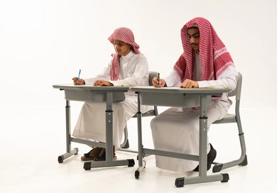 إيماءات الاجتهاد والتفوق، تطوير المناهج التعليمية في المملكة العربية, بورترية لطالبان عربيان خليجيان سعوديان يرتديان الثوب الابيض و الشماغ يجلسان على الطاولة يقومان بمراجعة الدروس للمذاكرة والاختبارات المدرسية، خلفية بيضاء