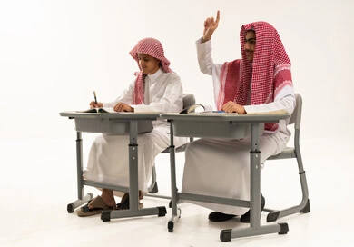 تعابير وايماءات الحماس لمعرفة الجواب الصحيح، تأدية الواجبات المدرسية، المشاركة والتفاعل داخل الفصل الدراسي، بورترية لطالبان عربيان خليجيان سعوديان يرتدين الثوب الابيض و الشماغ يجلسان على الطاولة فى الفصل، التربية والتعليم بالمناهج المقررة للطلاب في المملكة العربية السعودية، خلفية بيضاء