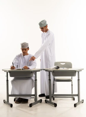 Teamwork and collaboration among colleagues, pointing to something, discussing study materials, completing school assignments, a portrait of two Arab Gulf students from Oman wearing the dishdasha and kumma sharing information, a new classroom, education in the Sultanate of Oman, white background.