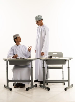 مناقشة المواد الدراسيه،  تأدية الواجبات المدرسية، العمل الجماعي والتعاون بين الزملاء، بورترية لطالبان عربيان خليجيان عمانيان يرتدين الدشداشة و الكمة يقومان بمشاركة المعلومات، فصل دراسي جديد، التعليم في سلطنه عمان، خلفية بيضاء