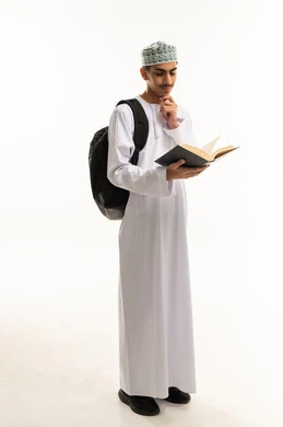إيجاد حل لمشكلة ما، مفهوم شرود الذهن و التأمل والتخطيط للمستقبل، بورتريه لطالب عربي خليجي عمانى يرتدي الدشداشة و الكمة يحمل حقيبة الظهريقرا كتاب و يضع يده على ذقنه بايماءات التفكير و الحيرة ، الجسم بالطول الكامل، خلفية بيضاء