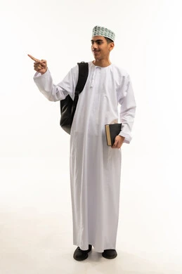 الإشارة باليد إلى شيء ما بعيد، موسم العودة إلى المدارس، الجد والاجتهاد للوصول إلى النجاح والتفوق، بورتريه لطالب عربي خليجي عمانى يرتدي الدشداشة و الكمة يحمل حقيبة الظهر و الكتب المدرسية ينظر بإيماءات السعادة و السرور، الجسم بالطول الكامل، خلفية بيضاء