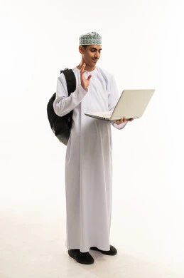 تعابير الترحيب والاستقبال، إجراء مكالمة فيديو باستخدام الابتوب، تبادل الأخبار مع الأهل والأصدقاء، بورتريه لطالب عربي خليجي عماني يرتدي الدشداشة والكمه و حقيبة الظهر يقوم بالتواصل مع الأقارب عبر الحاسب المحمول، صورة الجسم بالطول الكامل, خلفية بيضاء