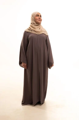 النظر الى شيء ما، مفهوم الأناقة والأنوثة, بورترية لإمراة كبيرة بالسن عربية سعودية خليجية محجبة ترتدي العباءة تقف باستقامة تنظر بايماءات الثقة بالنفس, الاهتمام بالمظهر الخارجي، الطول الكامل للجسم, خلفية بيضاء