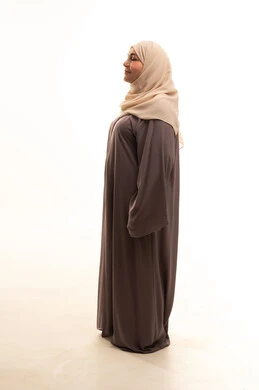 مفهوم الأناقة والأنوثة, بورترية من الجانب لإمراة كبيرة بالسن عربية سعودية خليجية محجبة ترتدي العباءة تقف باستقامة تنظر بايماءات الثقة بالنفس, الاهتمام بالمظهر الخارجي، الطول الكامل للجسم, خلفية بيضاء