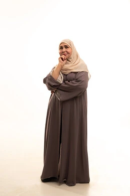 Looking at something with expressions of immersion and confusion, gestures of contemplation and reflection, a portrait of an elderly Arab Saudi Gulf woman wearing a hijab and an abaya, resting her hand under her head and thinking, lost in thought on a specific topic, finding solutions to a problem, full-body image, white background.