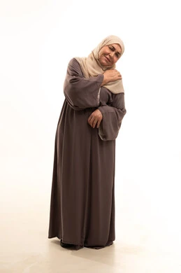 التهاب العضلات والمفاصل، الحاجه للعلاج وطلب المساعده، الشعور بالمرض و التعب، بورترية لإمراة كبيرة بالسن عربية سعودية خليجية محجبة ترتدي العباءة تضع يدها على كتفها بإيماءات تدل على الألم الشديد، صورة الجسم بالطول الكامل, خلفية بيضاء