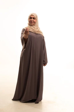 تعابير طلب الإنتظار والتمهل، مفهوم الصبر والتريث، بورترية لإمراة كبيرة بالسن عربية سعودية خليجية محجبة ترتدي العباءة ترفع يدها بتعابير تدل على الانتظار، صورة الجسم بالطول الكامل، خلفية بيضاء