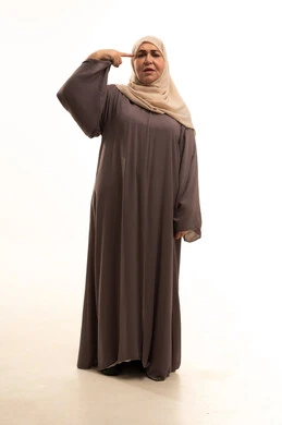 تحديد موقع شيء معين، إشارات وحركات يدين تدل على هذا المكان (هنا)،  بورترية لإمراة كبيرة بالسن عربية سعودية خليجية محجبة ترتدي العباءة تشير بإصبع السبابة إلى جهة اليمين، صورة الجسم بالكامل، خلفية بيضاء