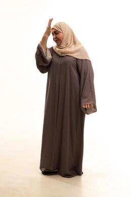 التذكر المفاجئ لشيء هام، التأخر على موعد ما, الإغفال والسهو والغفلة, بورترية لإمراة كبيرة بالسن عربية سعودية خليجية محجبة ترتدي العباءة تضع يديها على رأسها بتعابير النسيان والذهول, الجسم بالطول الكامل, خلفية بيضاء