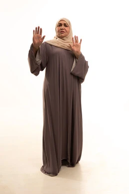 طلب التوقف و الامتناع و عدم الاقتراب, حماية النفس من ضرر خارجي, بورترية لإمراة كبيرة بالسن عربية سعودية خليجية محجبة ترتدي العباءة تنظر إلى الكاميرا و ترفع يديها بتعابير الخوف و الابتعاد, الجسم بالطول الكامل, خلفية بيضاء