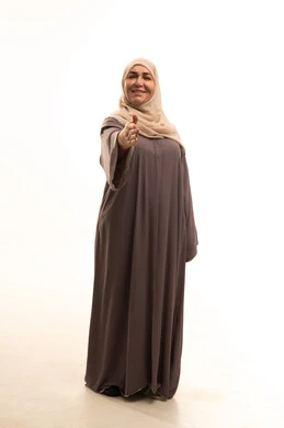 مفهوم الاستقبال والترحيب, التعارف و الصداقه وتكوين علاقات, إلقاء التحيه والسلام, بورترية لإمراة كبيرة بالسن عربية سعودية خليجية محجبة ترتدي العباءة تقوم بمد كفها للمصافحة، الجسم بالطول الكامل، خلفية بيضاء