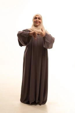 الحيرة والتردد في شيء ما،  بورترية لإمراة كبيرة بالسن عربية سعودية خليجية محجبة ترتدي العباءة ترفع اصبع الابهام للاعلى والاسفل بإيماءات عدم الموافقه والموافقه، تعابير عدم الإعجاب والإعجاب, مفهوم الرفض والقبول، الطول الكامل للجسم, خلفية بيضاء