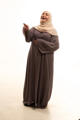 Expressions of hysterical laughter, a portrait of an elderly Arab Saudi Gulf woman in a hijab wearing an abaya, pointing to something, gestures of joy and happiness, full-body, white background.