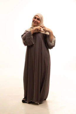 ايماءات يدين على شكل قلب، تعابير السرور والسعادة، اظهار مشاعر الحب والشغف، مفهوم المحبة والمودة، بورترية لإمراة كبيرة بالسن عربية سعودية خليجية محجبة ترتدي العباءة  تنظر إلى الكاميرا بتعابير السرور والسعادة، الجسم بالطول الكامل، خلفية بيضاء