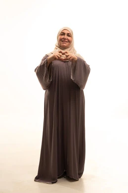 تعابير السرور والسعادة، ايماءات يدين على شكل قلب، اظهار مشاعر الحب والشغف، مفهوم المحبة والمودة، بورترية لإمراة كبيرة بالسن عربية سعودية خليجية محجبة ترتدي العباءة  تنظر إلى الكاميرا بتعابير السرور والسعادة، الجسم بالطول الكامل، خلفية بيضاء