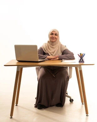 Business management and completing required tasks, remote work, a female profession and job, a portrait of an elderly Arab Saudi Gulf woman wearing a hijab and an abaya sitting at a table using a laptop, utilizing modern and advanced technology, looking at the camera with gestures of happiness and joy, white background. Business management and completing required tasks, remote work, a female profession and job, a portrait of an elderly Arab Saudi Gulf woman wearing a hijab and an abaya sitting at a table using a laptop, utilizing modern and advanced technology, looking at the camera with gestures of happiness and joy, white background.
