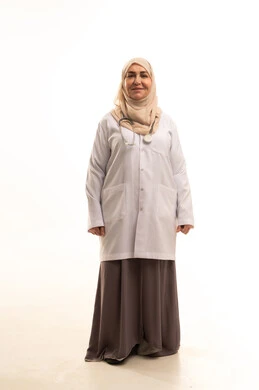 الوقوف باستقامة بايماءات الثقة بالنفس، العمل في القطاع الطبي، تقديم الخدمات الصحيه، بورتريه لطبيبة عربية خليجية سعودية كبيرة في السن ترتدي المعطف الطبي تنظر الى الكاميرا بتعابير السرور، صورة الجسم بالطول الكامل، خلفية بيضاء