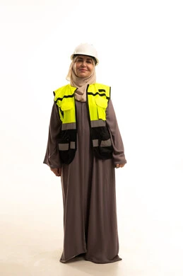 متابعة الأعمال والمخططات الهندسية ،الإعمار بسواعد أبناء الوطن ،الوقوف باستقامة وثقة، بورتريه لمهندسة عربية خليجية سعودية كبيرة في السن محجبة ترتدي سترة الحماية والخوذة تنظر الى الكاميرا بايماءات السعادة و السرور، مفهوم الهندسة و الانشاءات، صورة الجسم بالطول الكامل، خلفية بيضاء