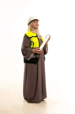 Architectural designs and plan auditing, development and growth of work in the engineering field, a portrait of an elderly Saudi Gulf Arab female engineer wearing a hijab, safety vest, and helmet holding a construction plan looking at something, engineering project management, women's professions and jobs, full-body, white background.