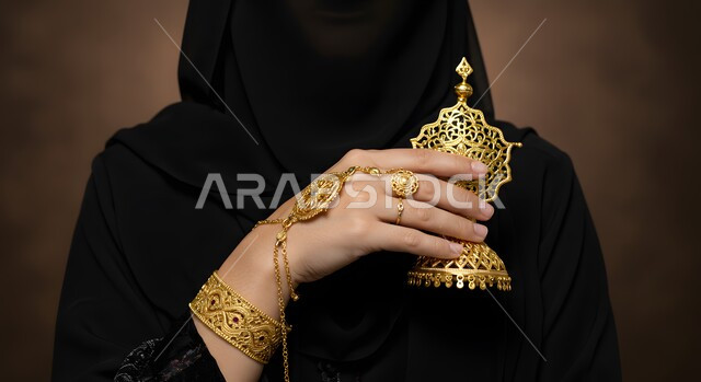 مقهوم التأنق والتجمل، الاهتمام بالمظهر الخارجي، الحلي المصنوعة بحرفية من الذهب الخالص، الاكسسوارات الثمينة في المملكة العربية السعودية، التصميمات الفريدة والمميزة للخواتم والأساور، امرأة عربية خليجية سعودية محجبة ترتدي مجوهرات ذهبية تقليدية