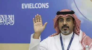 حركة يد وإشارات مختلفة, التحية والسلام والترحيب بشخص ما، رجل عربي خليجي سعودي يرتدي الثوب والشماغ والنظارة الطبية ويرفع يده بإيماءات طلب المشاركة في أمر ما، طلب الاذن للحديث في إحدى المؤتمرات