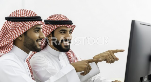 مفهوم التسليه والترفيه الجماعي,  بورتريه لصديقين عربيين خليجيين سعوديين يرتديان الشماغ والثوب التقليدي يقضيان وقت ممتع بمشاهدة الأفلام والمسلسلات المفضلة، تعابير وايماءات السعاده والسرور، الإشارة بإصبع السبابة إلى شيء ما