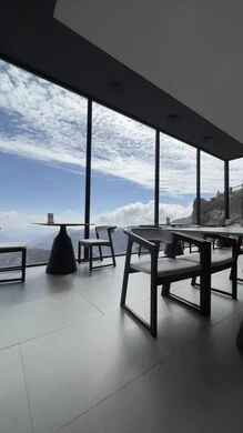 A cafe in the fog walkway above the natural terrain, rock formations and formations, peaks, heights and mountain ranges in the Namas Governorate in Asir, natural places and areas in the Kingdom of Saudi Arabia, a view of clouds and clouds in the sky, an area that attracts tourists and visitors