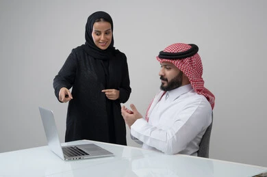 الحوار و النقاش بين الزملاء، بيئة العمل المريحة في الشركات السعودية، تبادل الخبرات والمعلومات لتحقيق الاهداف, بورتريه لموظفان عربيان خليجيان سعوديان يعملان في مكتبهم داخل مقر الشركة، استخدام الحاسب والتقنية في مجال الاعمال، خلفية رمادية