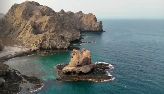Mountainous coastal areas for summer vacation in the Sultanate of Oman, the rocky beach of Sidab in Muscat Governorate, tourist places for recreation, entertainment, and spending a pleasant time, enjoying the natural scenery.