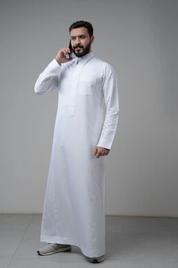 Conversation and chat using a modern technical device, answering a phone call, portrait of a Saudi Arabian Gulf man wearing traditional thobe making a phone call via mobile phone, full body image, white background