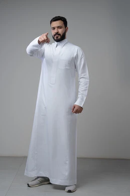 الاشارة الى الأمام، النظر الى الكاميرا  بتعابير الجدية والحزم، بورتريه لرجل عربي خليجي سعودي يرتدي الثوب التقليدي يشير بيده الى شيء ما، الدلالة على مكان معين، صورة الجسم بالطول الكامل، خلفية رمادية