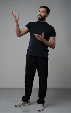 النظر الى الاعلى بتعابير التركيز، بورتريه لرجل عربي خليجي سعودي يرتدي الزي الكاجوال يشير بيده الى شيء ما، الدلالة على مكان معين، صورة الجسم بالطول الكامل، خلفية رمادية